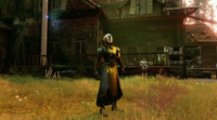 A Warlock standing near a house in the Farm.